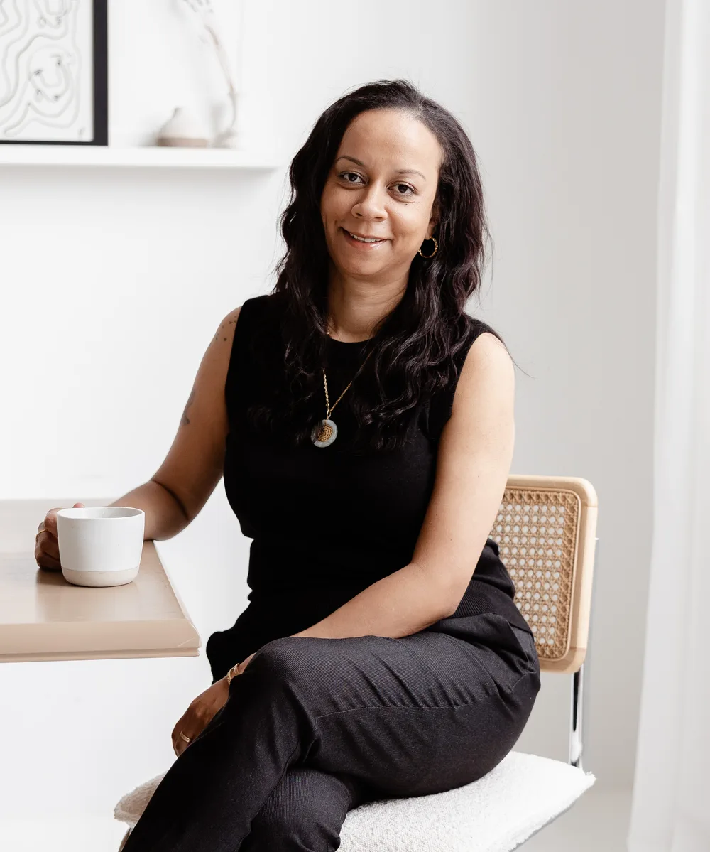 Gabrielle sitting at a table with a cup of coffee