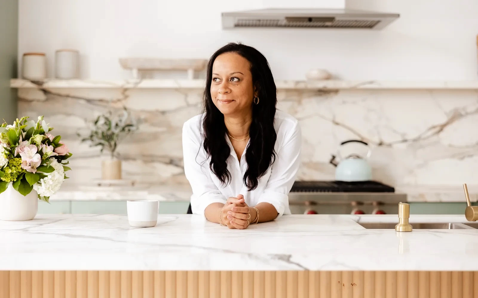 Gabrielle Thomas, founder of Upwellery, leaning on a marble kitchen counter
